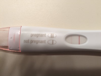 Analog pregnancy test showing a faint line indicating a positive result
